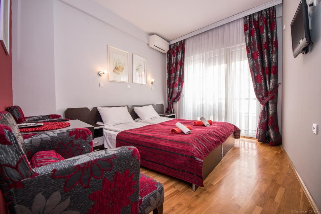 ein Schlafzimmer mit einem Bett, einem Sofa und einem Stuhl in der Unterkunft Villa Dudan LakeView in Ohrid