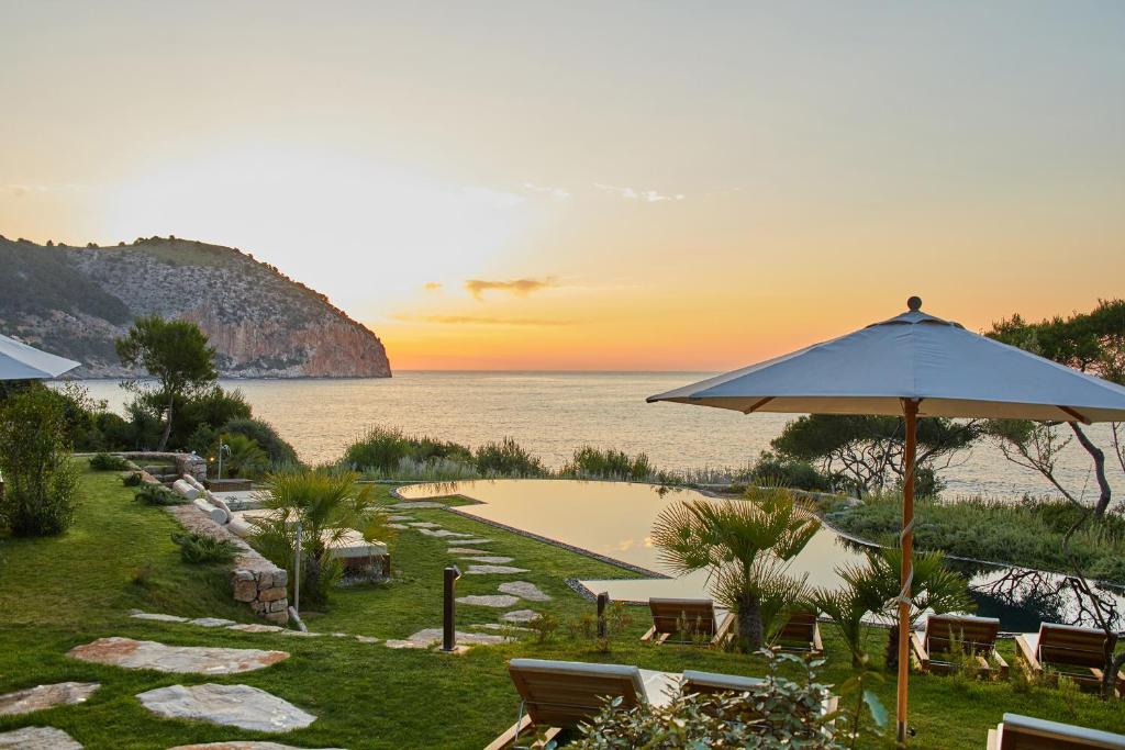 a beach with a view of the ocean and palm trees at Pleta de Mar, Luxury Hotel by Nature - Adults Only in Canyamel