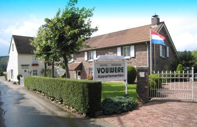 une maison avec un panneau devant une cour dans l'établissement B&B Vouwere, à Malines