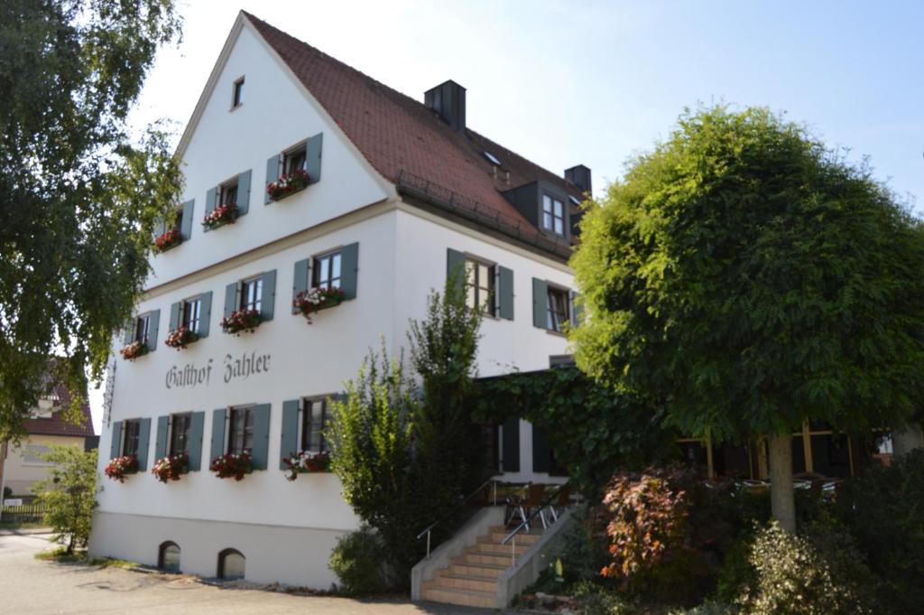 Röfingen的住宿－Gasthof Zahler，前面有一棵树的白色大建筑