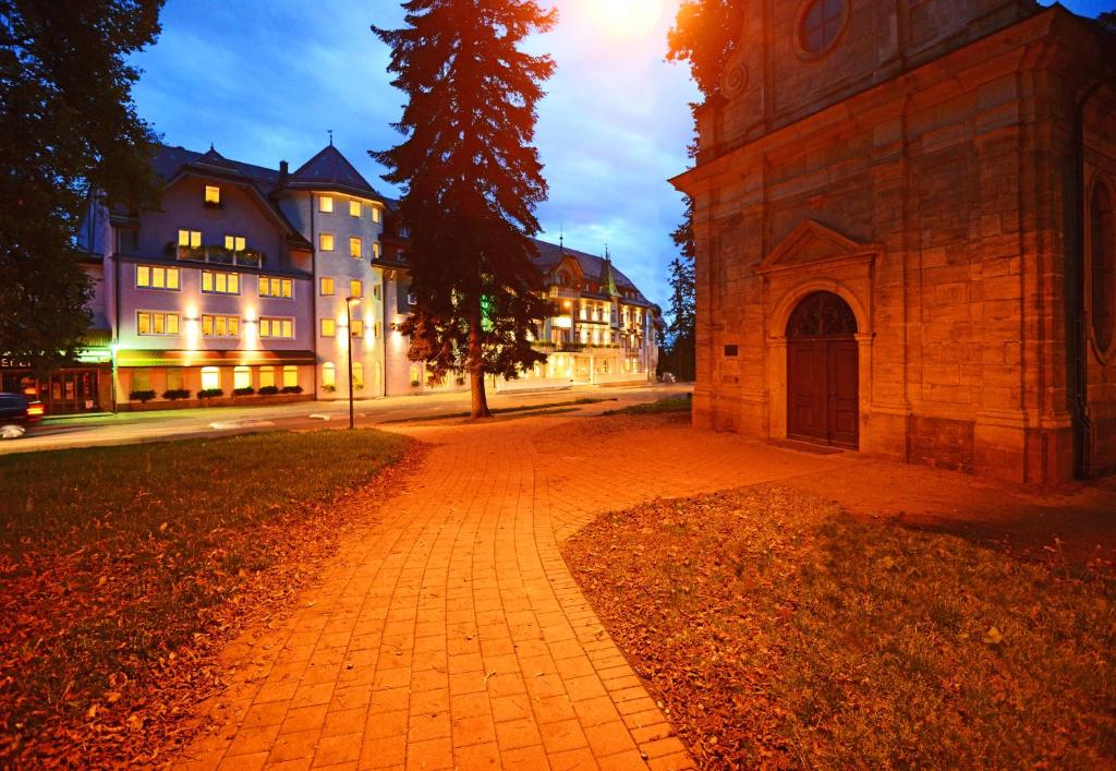 una calle adoquinada frente a un edificio por la noche en Möhringers Schwarzwald Hotel, en Bonndorf