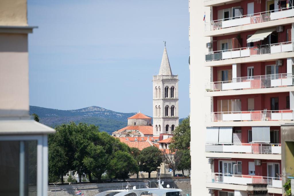 a building with a tower and a church with a steeple at Apartman Bordura in Zadar