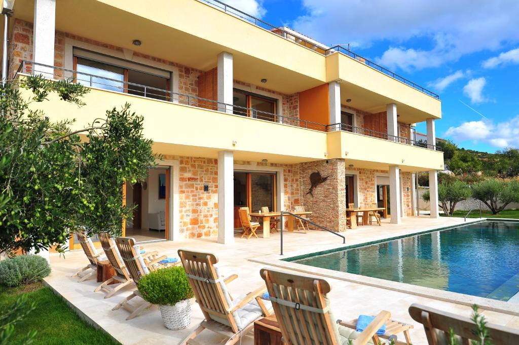 a villa with a swimming pool and a house at Villa Fora Hvar in Hvar