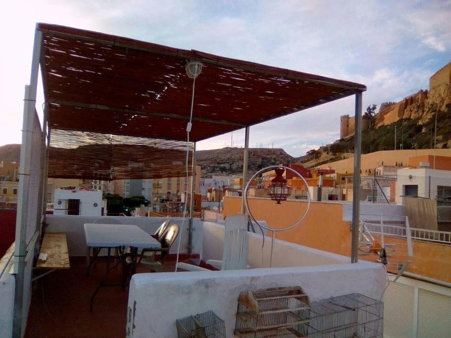 アルメリアにあるLinda casa pintoresca (Centro Almería)のバルコニー(テーブル、バスケットボールフープ付)の上に日よけが備わります。