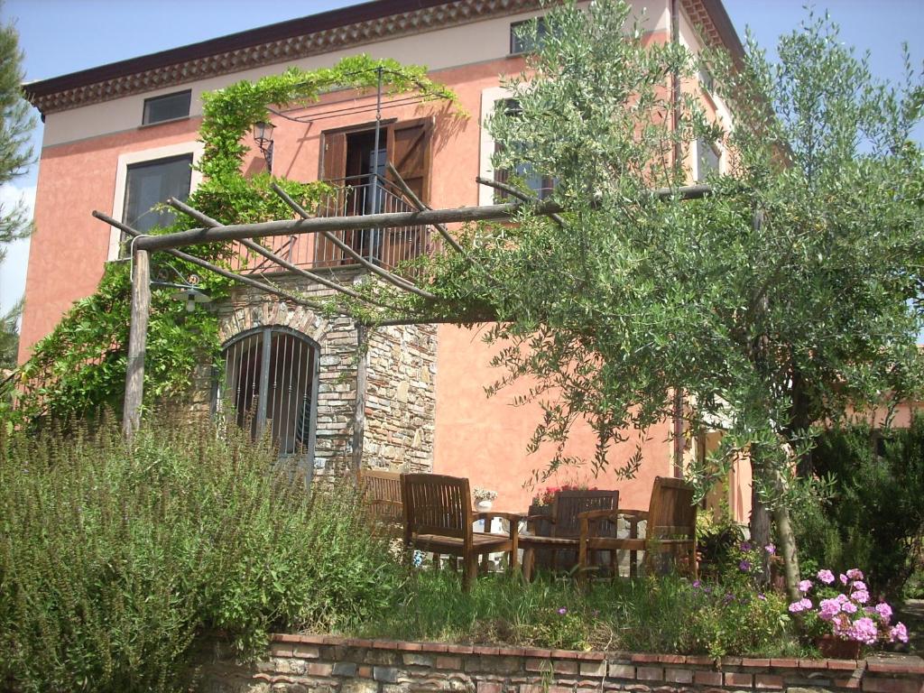 una casa con dos sillas y una mesa frente a ella en Agriturismo i Moresani, en Casal Velino