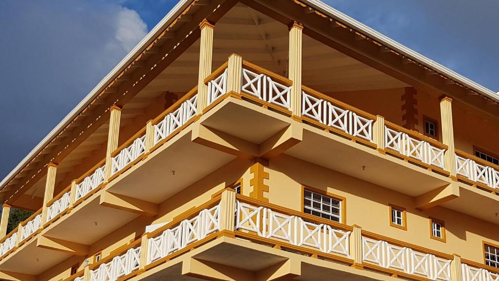 un edificio amarillo con balcones blancos en Sunburst en Arnos Vale