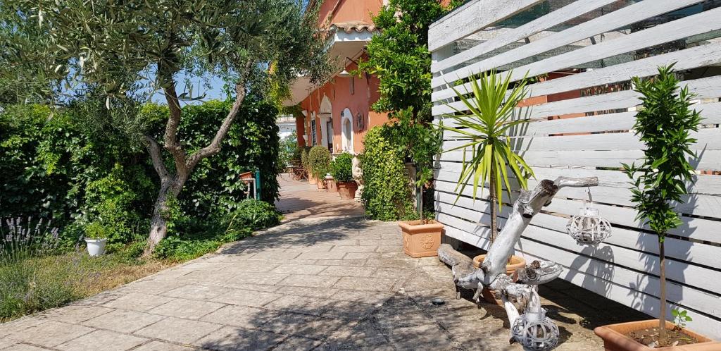 a white fence with statues of cats on the side of a sidewalk at Casale Terra Sole B&B in Terlizzi