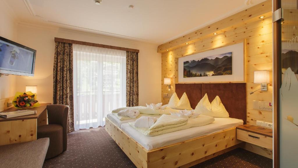 ein Hotelzimmer mit einem Bett und einem Fenster in der Unterkunft Hotel Lohningerhof in Maria Alm am Steinernen Meer
