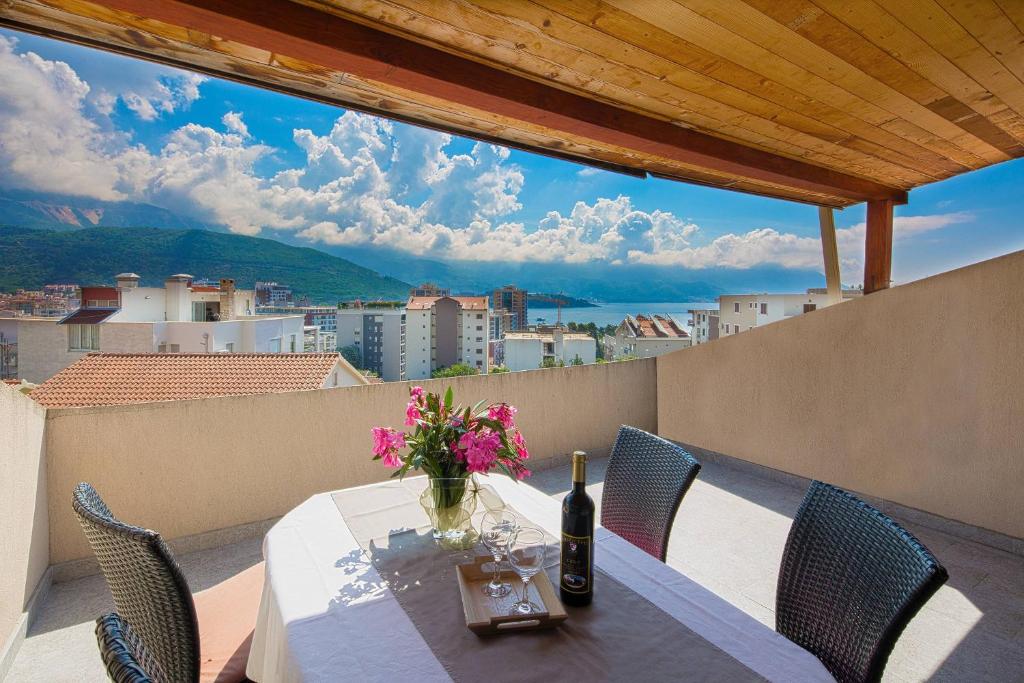 een tafel met een vaas met bloemen op een balkon bij Astor apartments in Budva