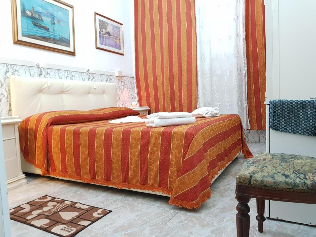 ローマにあるAlbergo Stadlerのベッドと椅子付きのホテルルーム