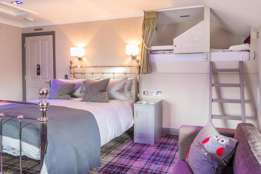 a bedroom with a bed and bunk beds with a ladder at The Sawley Arms in Ripon