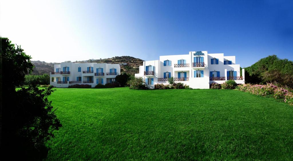 a large white building on top of a green field at Likio Studios in Batsi