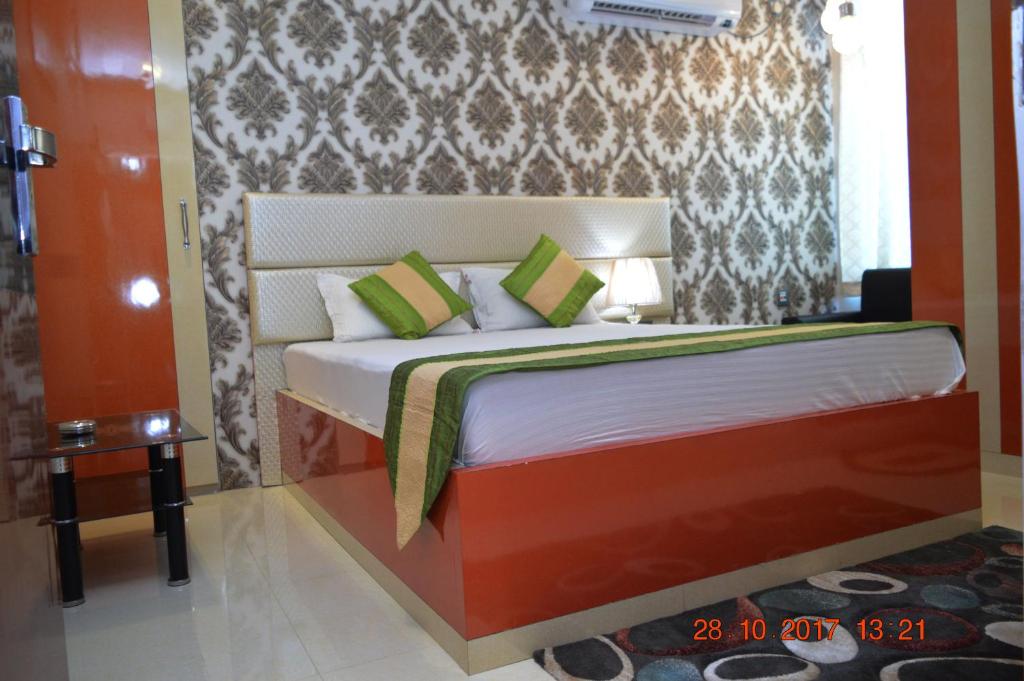 a bedroom with a large bed with green pillows at Hotel Biswanath in Guwahati