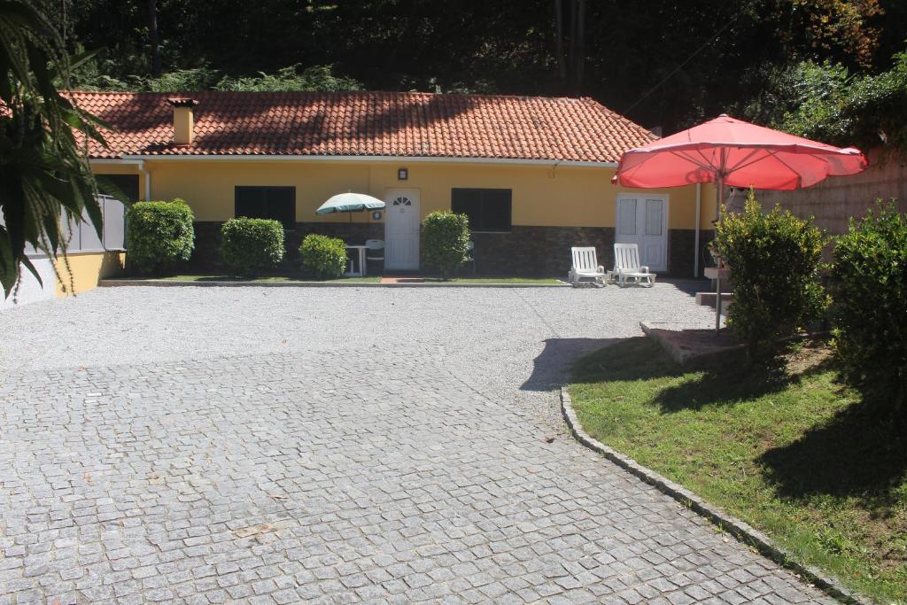 een patio met 2 parasols en stoelen en een huis bij Casinha dos Cubos in Geres