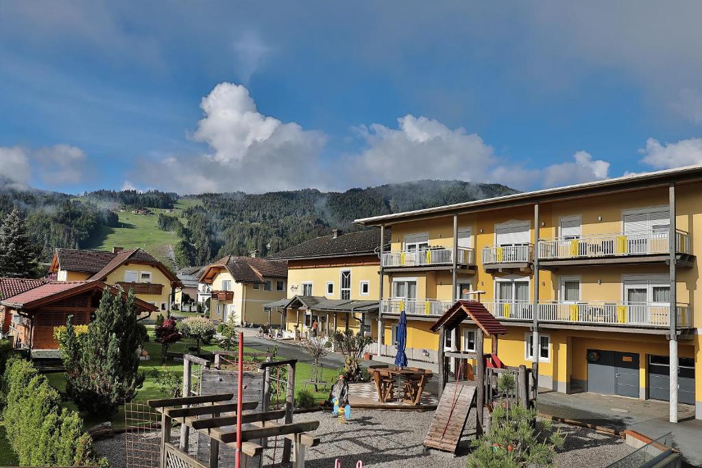 um grupo de edifícios com montanhas ao fundo em Hotel Garni Zerza em Tröpolach