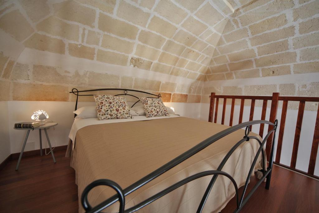 マンドゥーリアにあるLa Buona Creanzaのレンガの壁のドミトリールームのベッド1台分です。