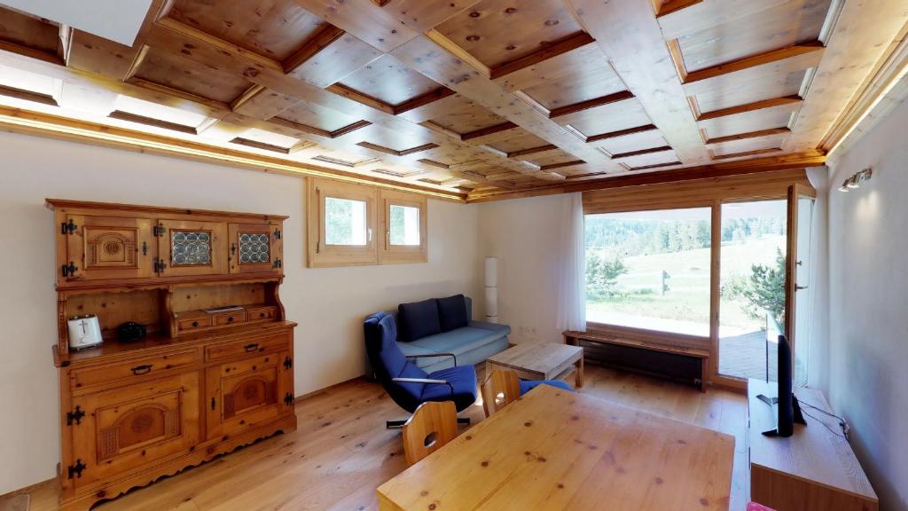 サンモリッツにあるPark Saletの木製の天井とテーブル付きのリビングルーム