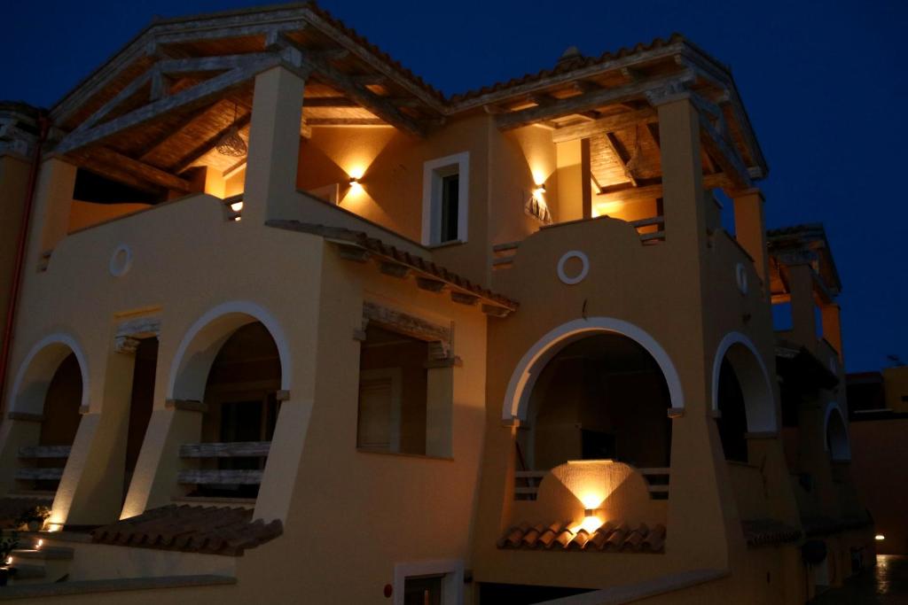 una casa di notte con luci sul balcone di La rosa dei venti a Villasimius