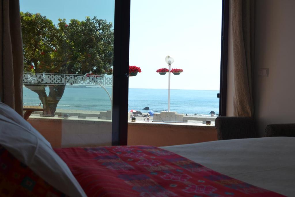 a bedroom with a bed and a view of the ocean at Hostel D'Avenida in Vila Praia de Âncora