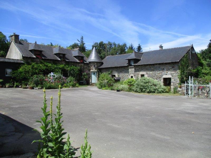 ein großes Gebäude mit einem Parkplatz davor in der Unterkunft Le Petit Chateau, Matisse in Noyal-Pontivy