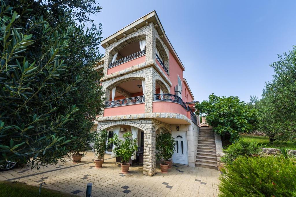 una casa grande con una escalera delante de ella en Apartments Orkula, en Maslenica