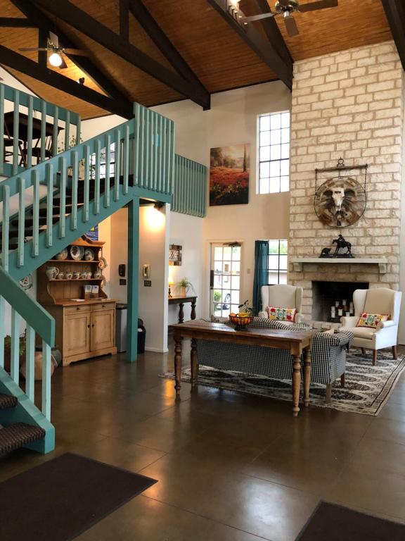 ein Wohnzimmer mit einer Treppe und einem Tisch in der Unterkunft Windcrest Inn and Suites in Fredericksburg