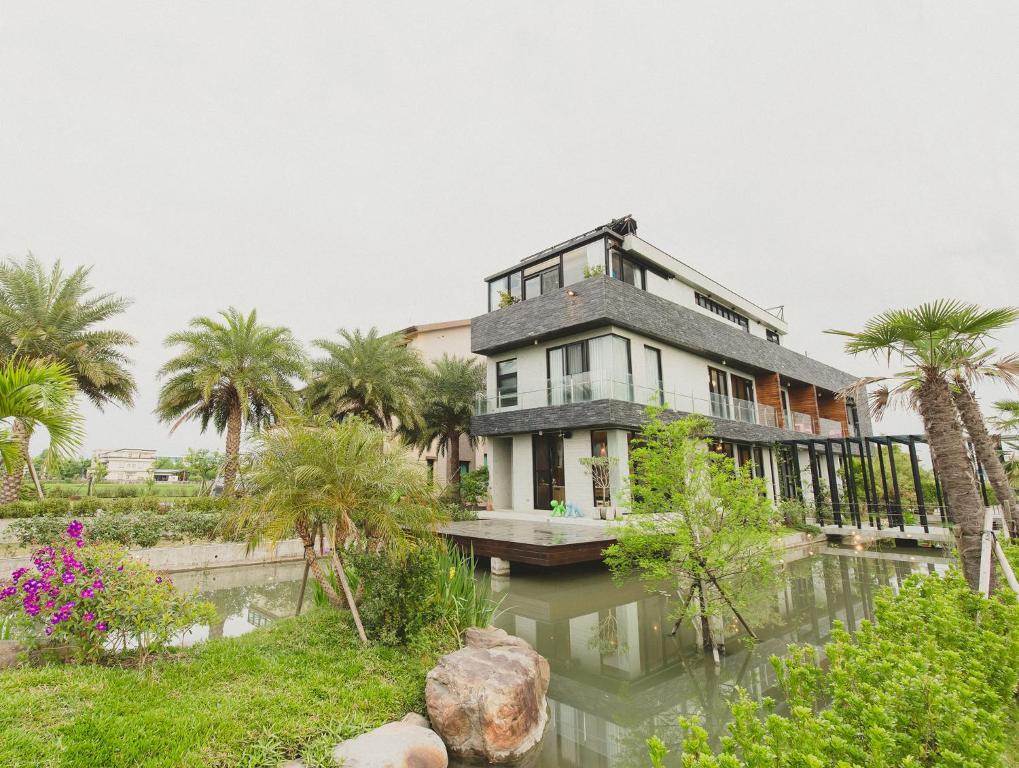 een huis aan het water met palmbomen bij Island Sunrise in Dongshan