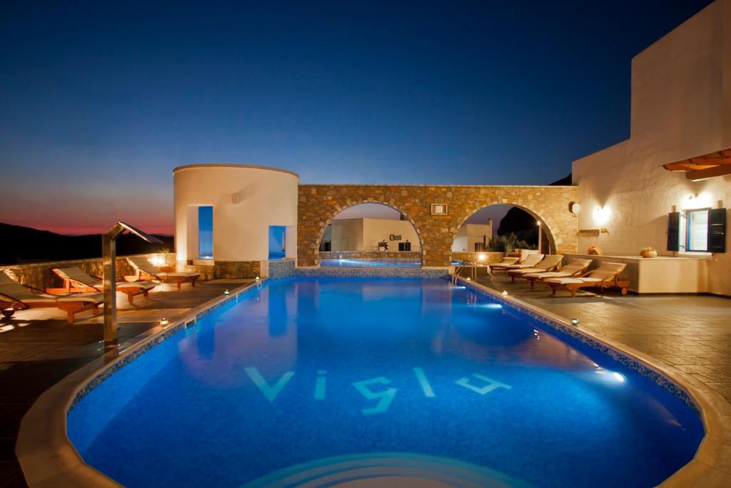 a swimming pool in a resort at night at Vigla Hotel in Aegiali