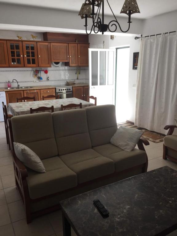 ein Wohnzimmer mit einem Sofa und einer Küche in der Unterkunft Casa Circular Norte in Nazaré