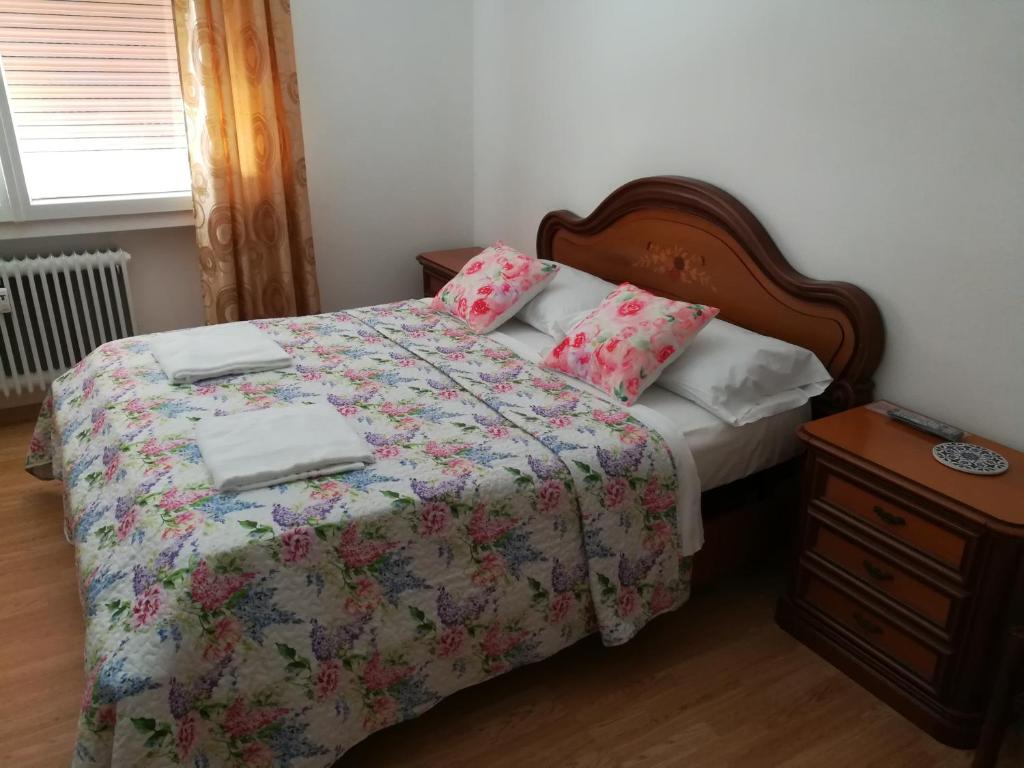 una camera da letto con un letto con copriletto e cuscini floreali di Venice Vacation House a Marghera