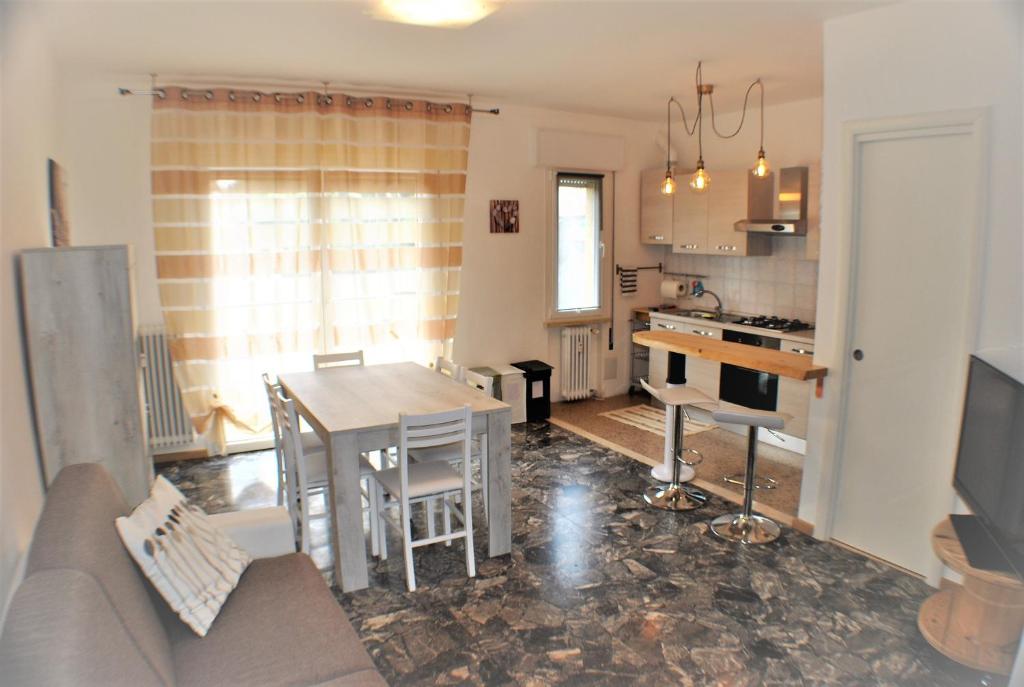 sala de estar y cocina con mesa y sofá en Casa Felice, en Favaro Veneto