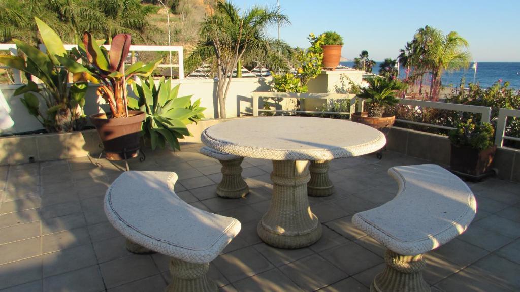 a patio with a table and two chairs and the ocean at Home4Holidays in Nerja