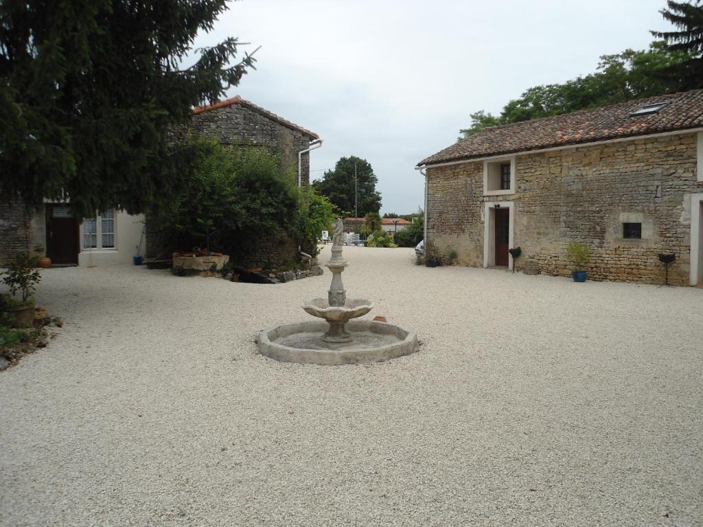 una fuente de piedra en medio de un patio en Les Papillon - Butterfly, en Villiers-le-Roux