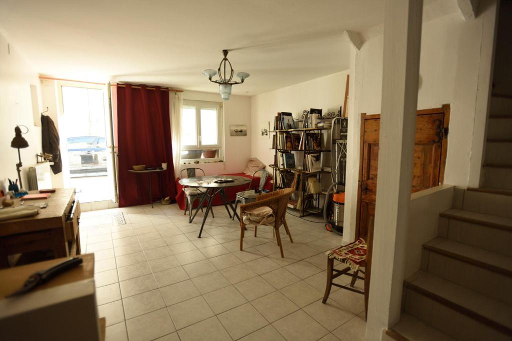 un salon avec une table et des chaises et une cuisine dans l'établissement la chambre claire, à Sigean