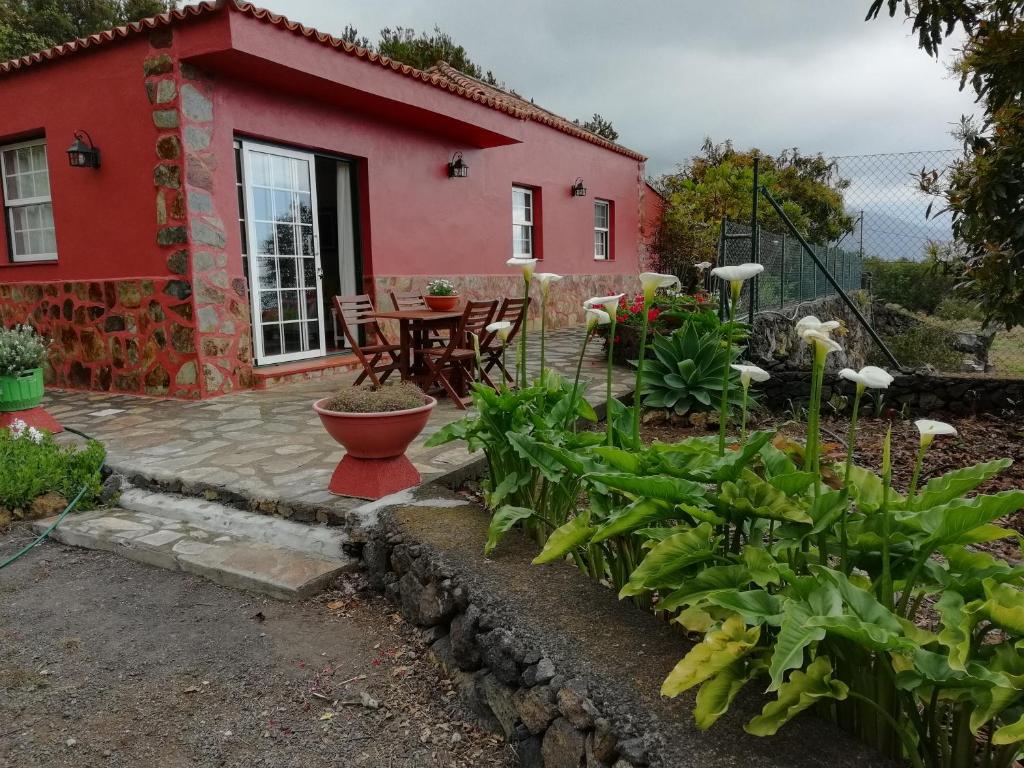 a red house with a patio and a table at Casa Heydi in Breña Alta