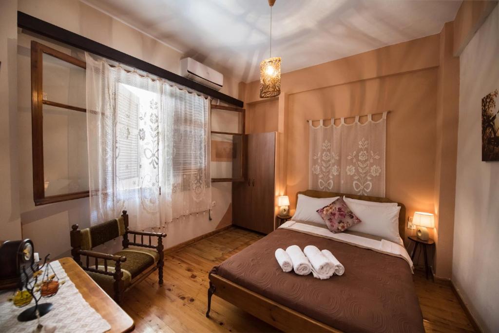 Un dormitorio con una cama y una silla y una ventana. en Manthiata Studios, en Exanthia