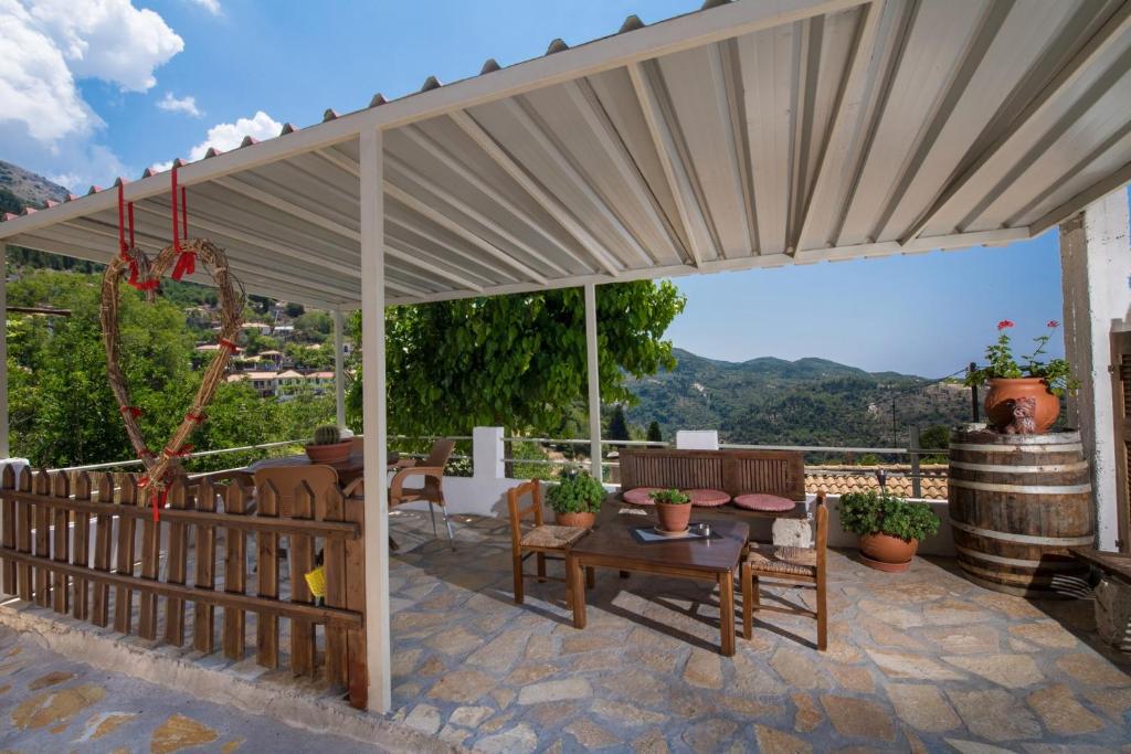 un patio con toldo, mesa y sillas en Manthiata Studios, en Exanthia
