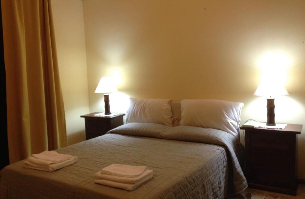 una camera da letto con un letto e asciugamani di Sturzo boutique home a Catania