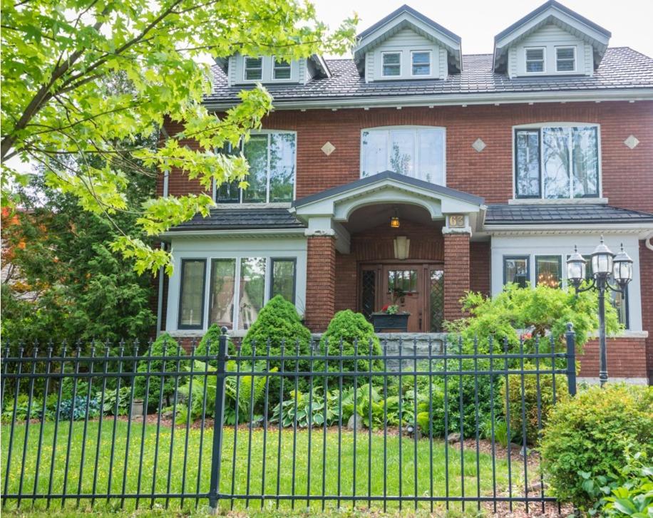 een stenen huis met een hek ervoor bij Avonview Manor in Stratford