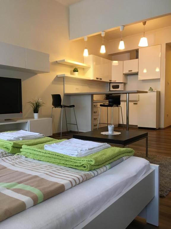 a bedroom with a bed with a table and a kitchen at Arany Janos Apartman in Budapest