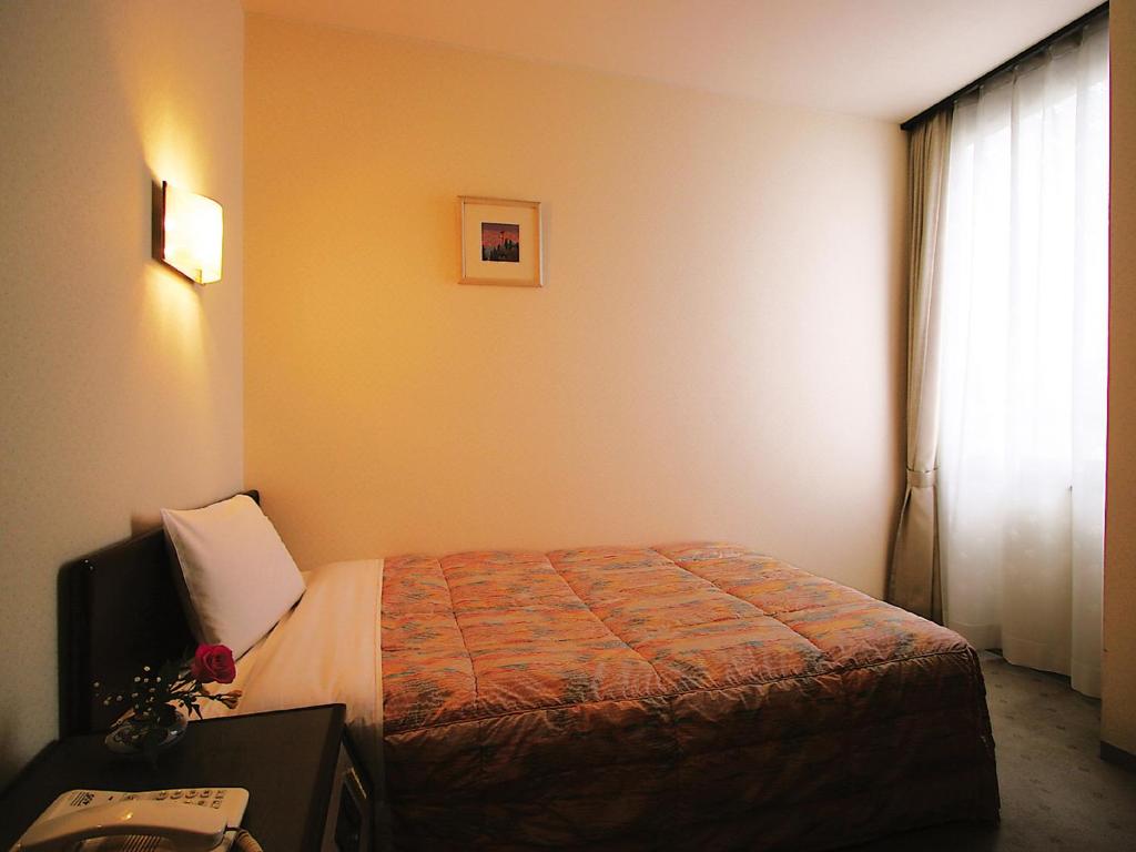 Postel nebo postele na pokoji v ubytování Kotohira Riverside Hotel