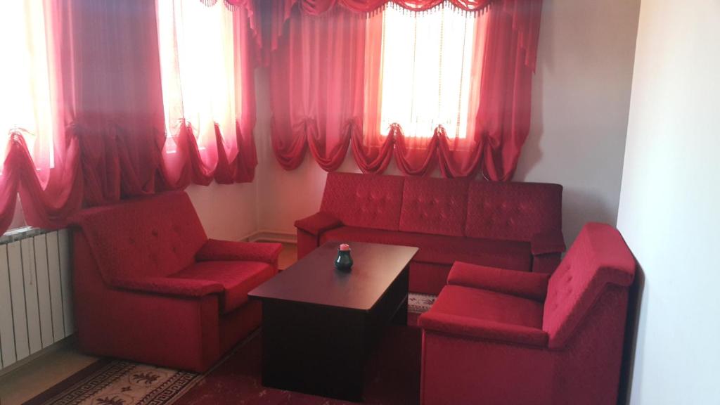 ein Wohnzimmer mit roten Stühlen, einem Tisch und Fenstern in der Unterkunft "Park" in Visoko