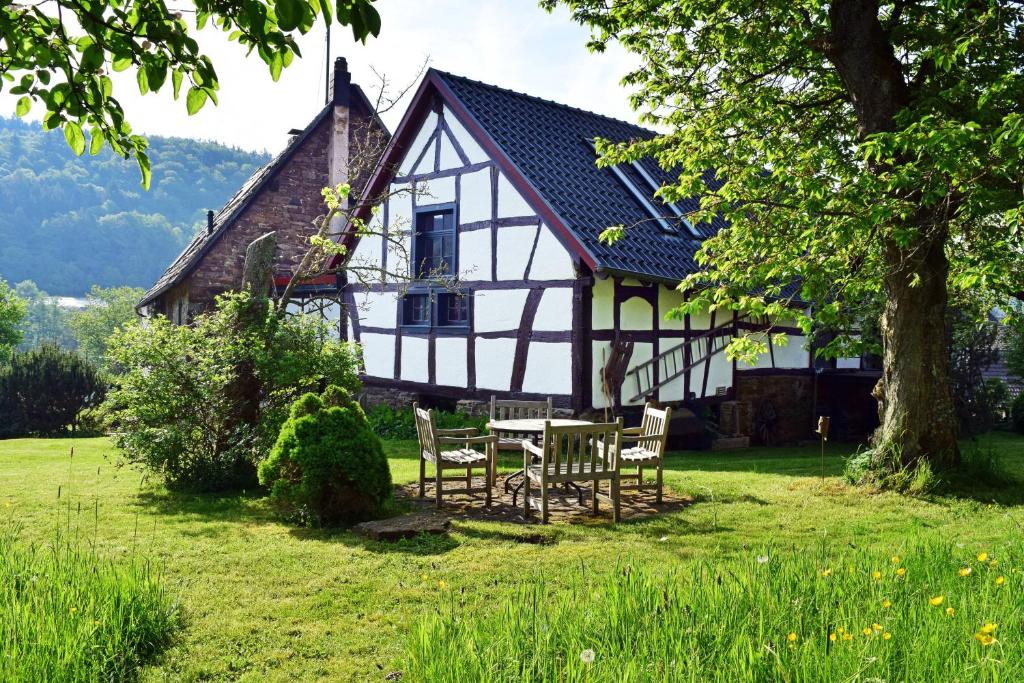 a house with a table and chairs in front of it at Landhaus am Aremberg / Eifel in Antweiler