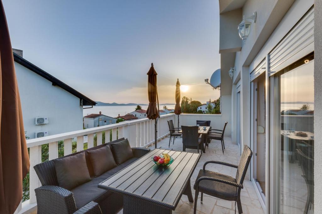 eine Terrasse mit einem Tisch und Stühlen auf dem Balkon in der Unterkunft Memories Apartments in Sveti Petar