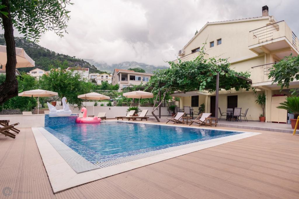 una piscina in un hotel con sedie e ombrelloni di Matej a Budua