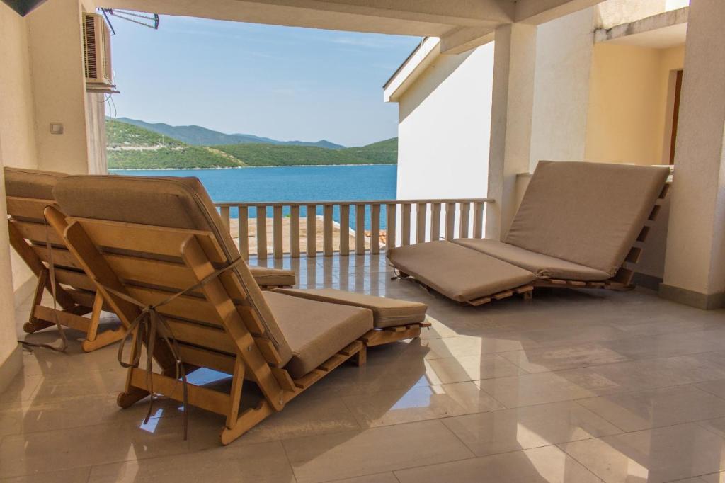 two lounge chairs on a balcony with a view of the water at Apartmani Maris in Neum