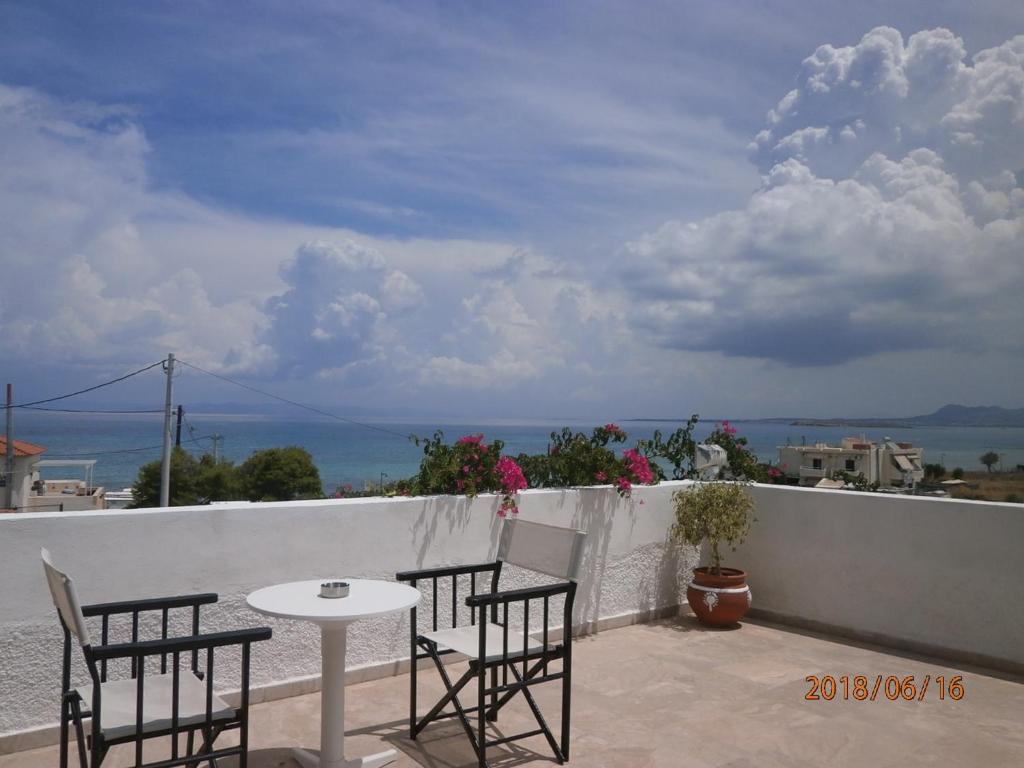 a table and chairs on a balcony with a view of the ocean at Hotel Flisvos in Megalochori