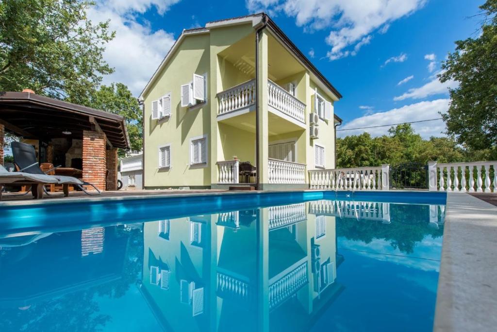 a house with a swimming pool in front of it at FEWO Villa Adria in Barušić