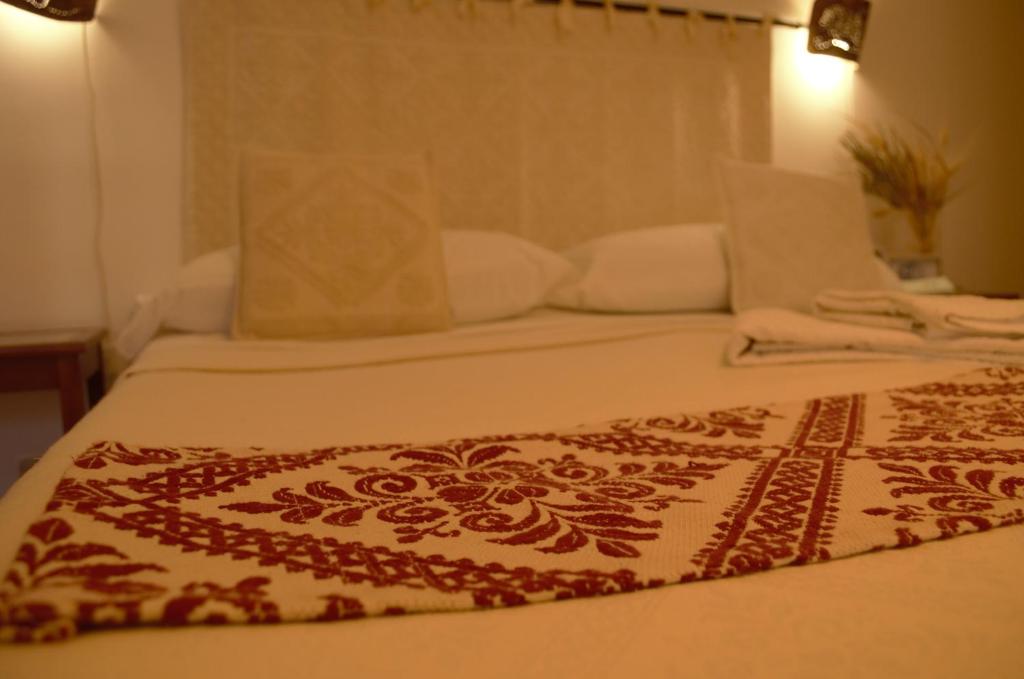 ein Bett mit einer roten und weißen Decke drauf in der Unterkunft Antonhouse Alghero in Alghero