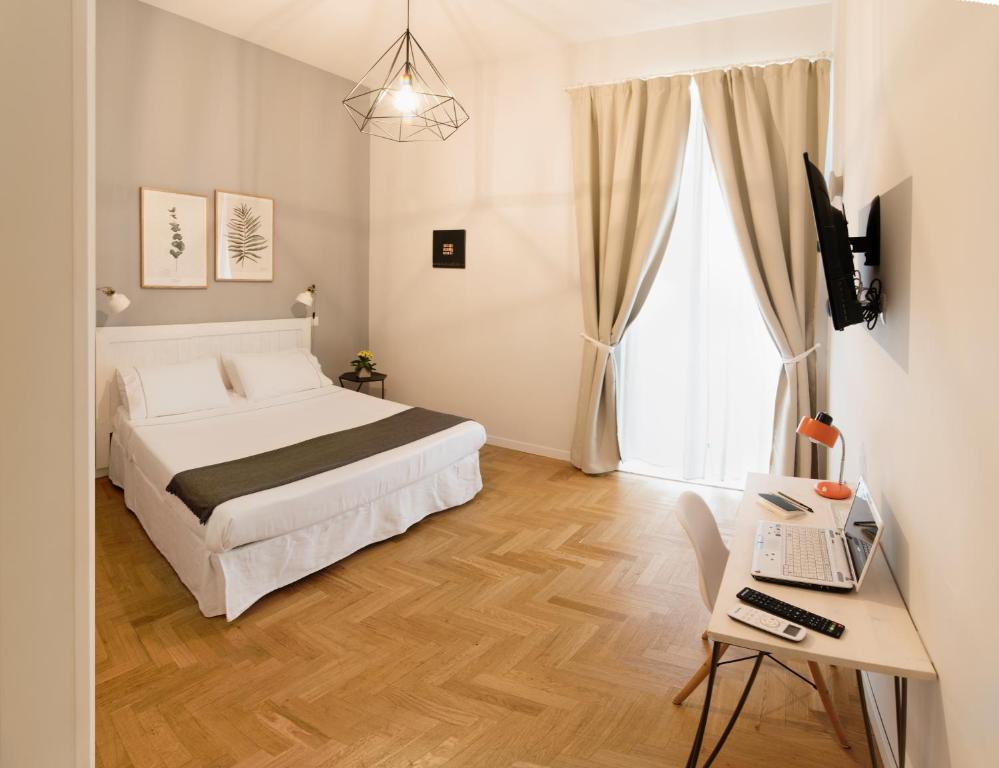 1 dormitorio con 1 cama y escritorio con ordenador portátil en The Andy House B&B, en Nápoles